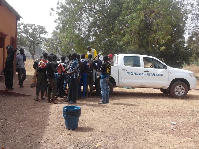 Des Burkinabè rapatriés de la Guinée se battant pour des friperies